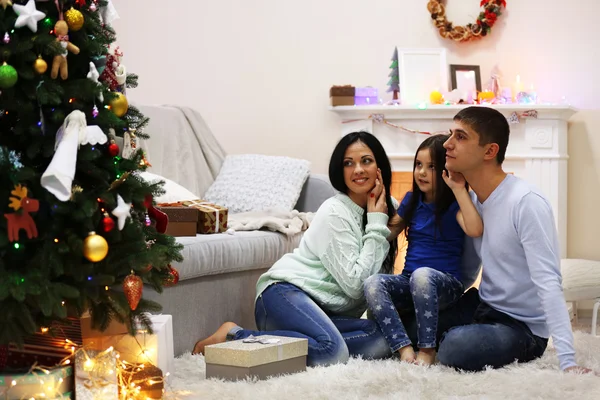 Famiglia felice sul pavimento con regali nella stanza decorata di Natale — Foto Stock