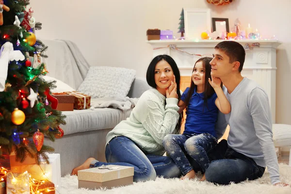 Familia feliz en el suelo con regalos en la habitación de Navidad decorada —  Fotos de Stock
