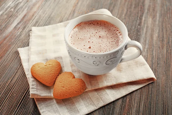 Чашка гарячого какао з печивом у формі серця на бавовняній серветці — стокове фото
