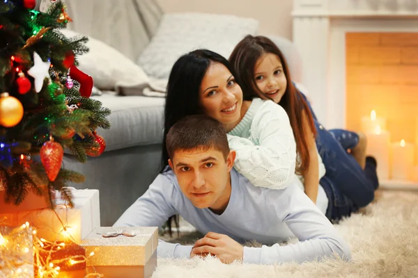 Šťastná rodina na podlaze s dárky v zdobené vánoční pokoj — Stock fotografie