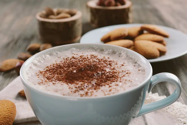 Tasse heißen Kakao auf Baumwollserviette mit Zimt, Mandeln und herzförmigen Keksen, Nahaufnahme — Stockfoto