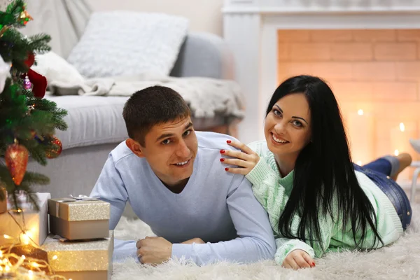 Casal feliz no chão com presentes na sala de Natal decorada — Fotografia de Stock