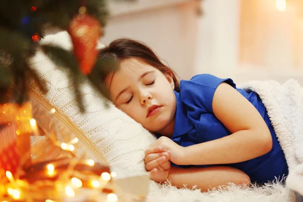 Hübsches kleines Mädchen schläft auf gemütlichem Sofa im weihnachtlich dekorierten Zimmer — Stockfoto