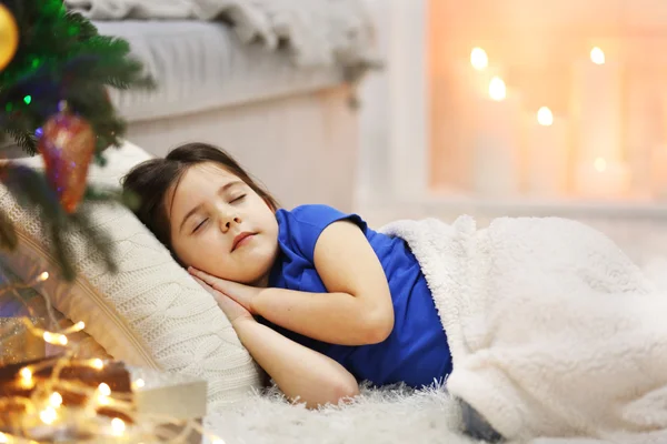 Menina bonita dormindo no sofá aconchegante no quarto decorado de Natal — Fotografia de Stock