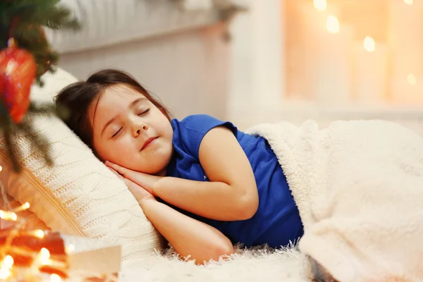 Hübsches kleines Mädchen schläft auf gemütlichem Sofa im weihnachtlich dekorierten Zimmer — Stockfoto