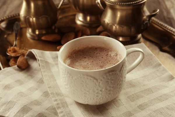 Secangkir coklat panas pada serbet kapas terhadap layanan perak — Stok Foto