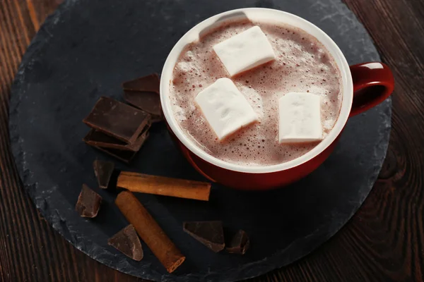 Tasse heißen Kakao mit Marshmallow, Zimt und Süßigkeiten auf blauer Serviette, Nahaufnahme — Stockfoto