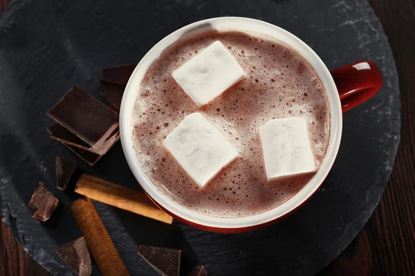 Xícara de cacau quente com marshmallow, canela e doces em serviette azul, close-up — Fotografia de Stock