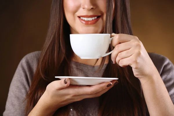Woman holds cup of coffee and plate in hands, close up — Stock Photo, Image