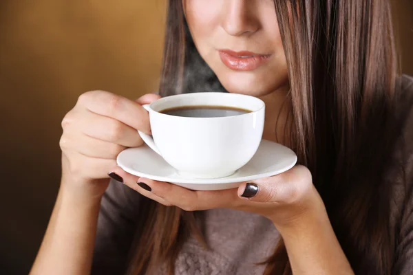 Mulher segura xícara de café e pires nas mãos, de perto — Fotografia de Stock