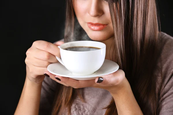 Woman holds cup of coffee and saucer in hands, close up — Stock Photo, Image