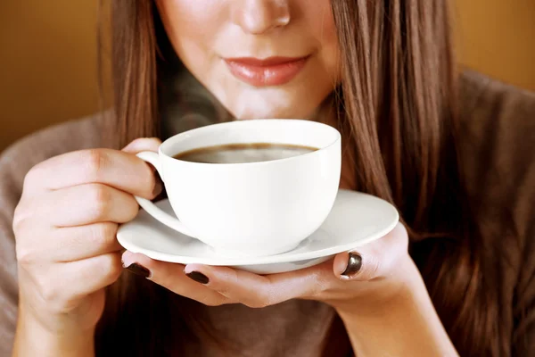 Woman holds cup of coffee and saucer in hands, close up — Stock Photo, Image