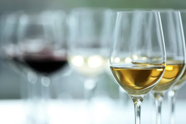 Vinhos com vinho branco e tinto sobre mesa de madeira sobre fundo brilhante — Fotografia de Stock