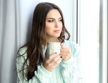 Kahve ile pencere gemide oturan güzel kadın