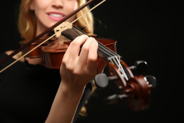 Müzisyen siyah arka plan üzerine keman çalıyor, yakın çekim