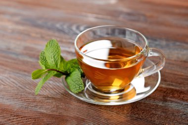Cam bardak çay nane ile ahşap arka plan üzerinde bırakır