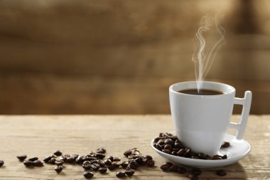 Fincan kahve ve kahve taneleri ahşap arka plan üzerinde