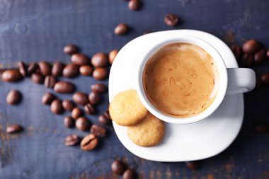 Ahşap masa arkasında bir fincan kahve.