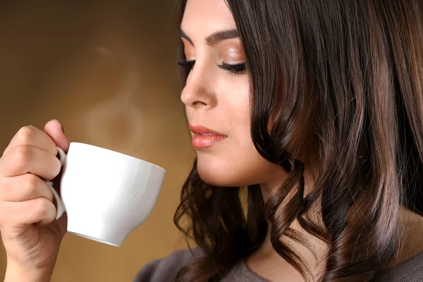 Porträt einer lächelnden hübschen Frau mit einer Tasse Kaffee — Stockfoto