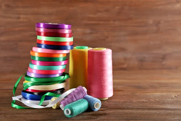 Spoelen van kleur lint, draad op houten achtergrond — Stockfoto