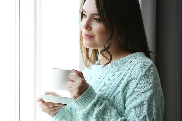 Mujer de pie cerca de la ventana en la habitación, de cerca — Foto de Stock