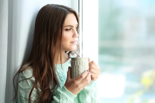 Красивая женщина сидит на доске с чашкой кофе — стоковое фото