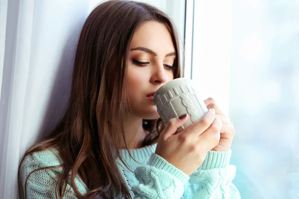 Frau trinkt Kaffee am Fenster im Zimmer — Stockfoto