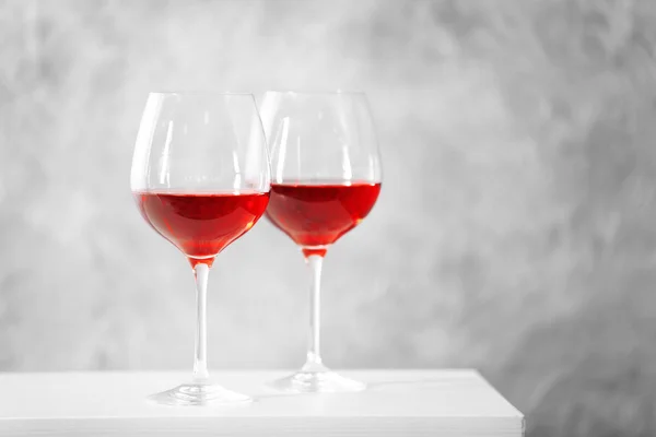 Due bicchieri di vino rosso con accessori natalizi su sfondo grigio — Foto Stock