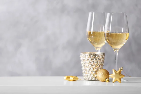 Due bicchieri di vino con giocattoli natalizi su sfondo grigio — Foto Stock