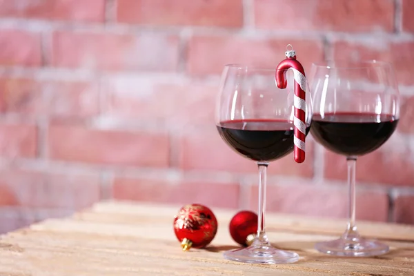 Two glasses of wine with christmas toys on wall background — Stock Photo, Image