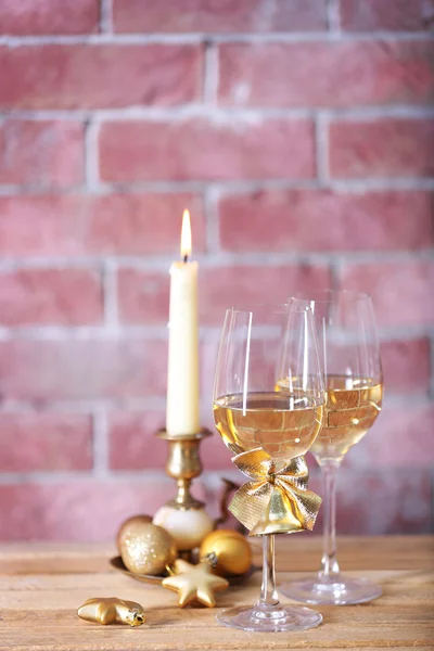 Δύο ποτήρια κρασί με κερί και χριστουγεννιάτ σε φόντο τοίχο — Φωτογραφία Αρχείου