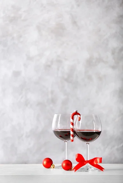 Dos copas de vino con accesorios navideños sobre fondo gris —  Fotos de Stock