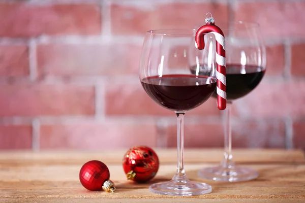 İki bardak şarap duvar arka plan üzerinde Noel oyuncaklar ile — Stok fotoğraf
