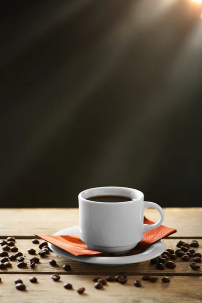 Tazza di caffè e chicchi di caffè su tavolo di legno, su sfondo grigio — Foto Stock