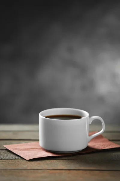 Kopje koffie en koffie korrels op houten tafel, op grijze achtergrond — Stockfoto