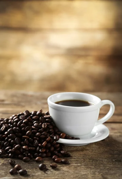 Fincan kahve ve kahve taneleri ahşap arka plan üzerinde — Stok fotoğraf