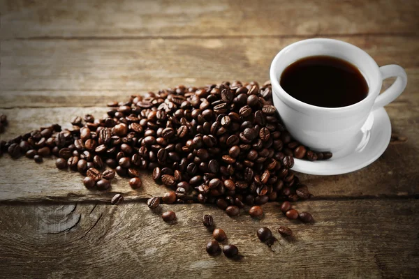 Csésze kávé és kávé szemes fából készült háttér — Stock Fotó