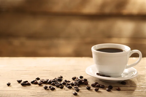 一杯のコーヒーとコーヒー粒木製の背景 — ストック写真