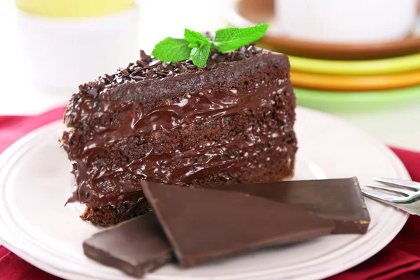 Gâteau au chocolat avec crème au chocolat sur assiette, sur fond clair — Photo