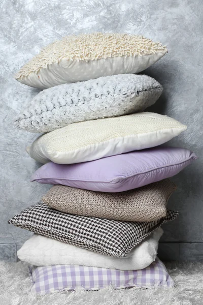 Few pillows on grey wall background — Stock Photo, Image