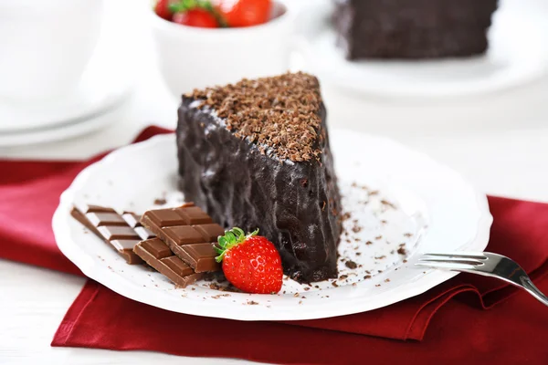 Chocolate cake with chocolate cream and fresh strawberries on plate, on light background — Stock Photo, Image