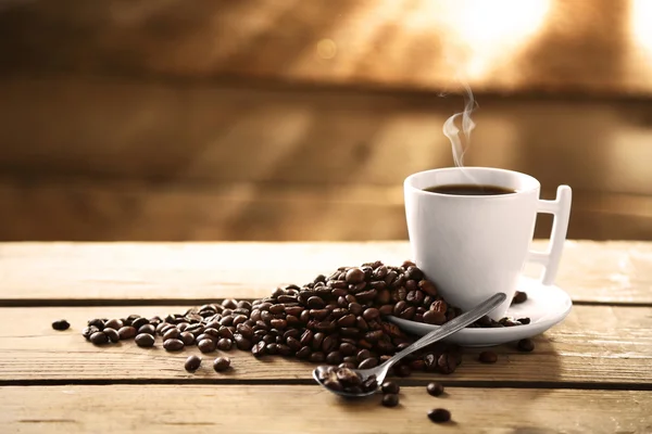 Xícara de grãos de café e café em fundo de madeira — Fotografia de Stock