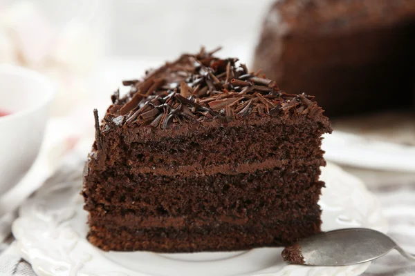 Pastel de chocolate en rodajas sobre mesa de madera, sobre fondo claro — Foto de Stock