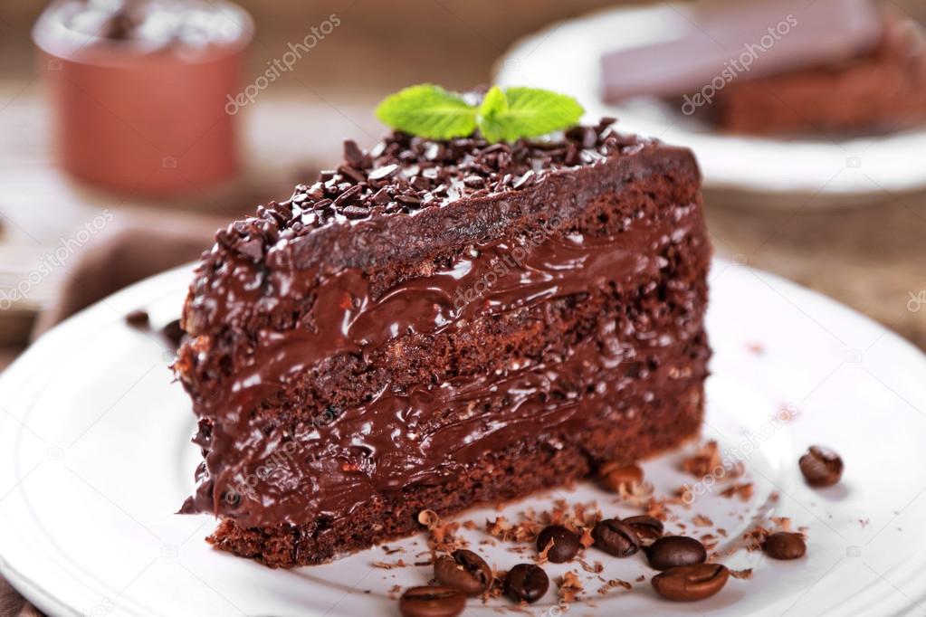 Chocolate cake with chocolate cream and fresh berries on plate, on wooden background