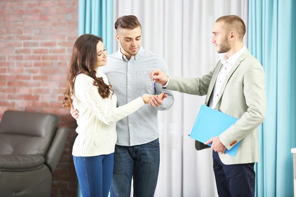 Estate agent giving keys to couple — Stock Photo, Image