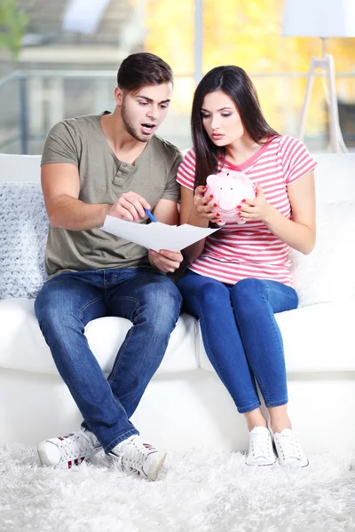 Happy couple deciding how to spend money from the moneybox — Stock Photo, Image