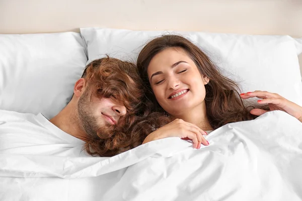 Feliz pareja descansando en la cama — Foto de Stock