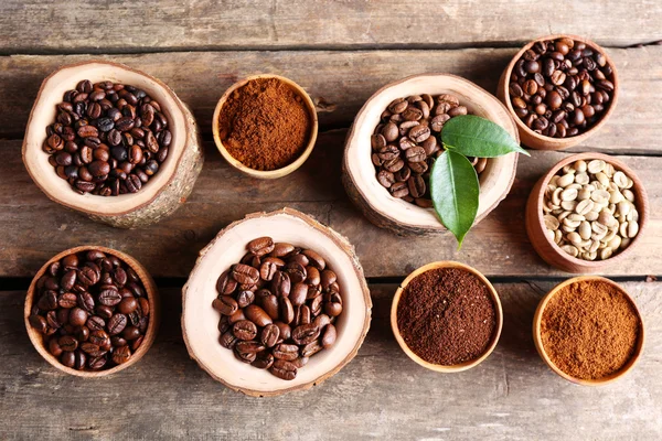 Verschillende koffiebonen op houten tafel — Stockfoto