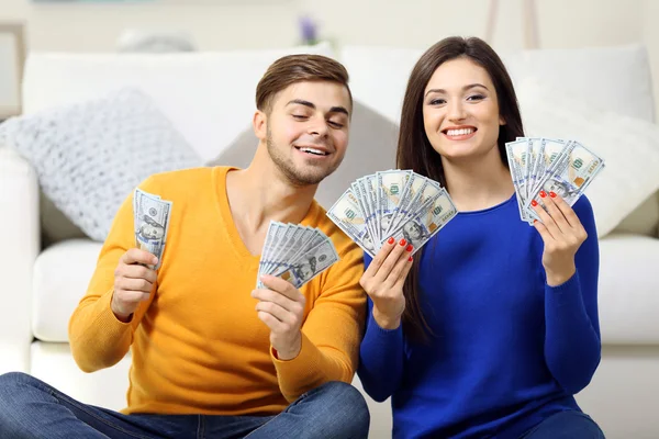 Pareja feliz en una habitación con dinero — Foto de Stock