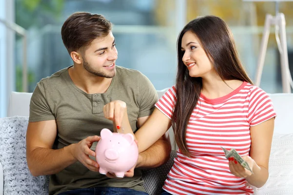 Счастливая пара считает деньги из копилки — стоковое фото